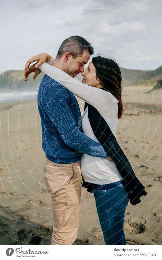 Pregnant woman hugging partner on the beach Lifestyle Happy Beach Ocean Winter Human being Baby Woman Adults Man Parents Mother Father Family & Relations Couple