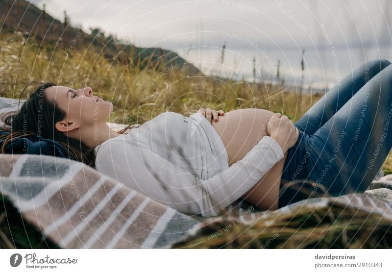 Pregnant woman caressing her tummy sleeping on grass Lifestyle Beautiful Relaxation Human being Baby Woman Adults Mother Family & Relations Nature Landscape