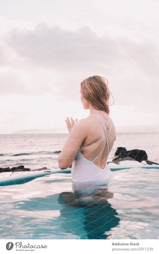 Woman sitting in pool near stones Swimming pool Stone Youth (Young adults) Resting Water Closed eyes Rock Sky Clouds Summer Body Relaxation Healthy Nature