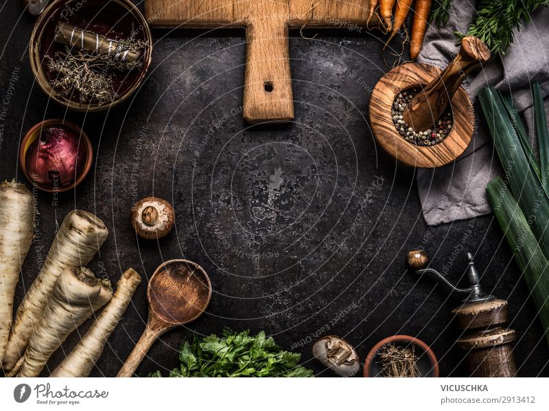 Rustic food background with root vegetables, herbs,spices ,leek and champignon mushrooms on dark rustic table with kitchen utensils, top view. Mushroom