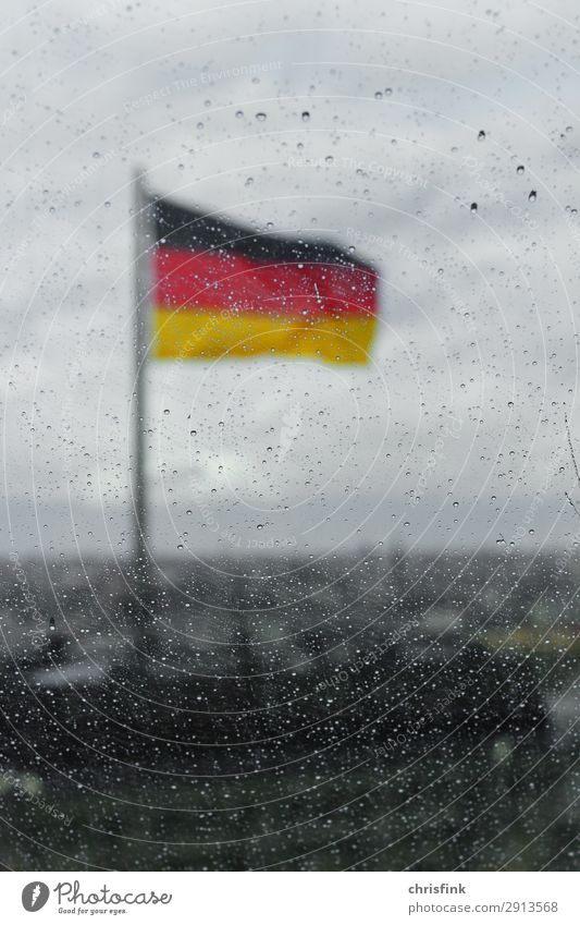 German flag behind drops on glass pane in Berlin Town House (Residential Structure) Building Roof Glass Sign Flag Cold Rain Blur Germany Colour photo Evening