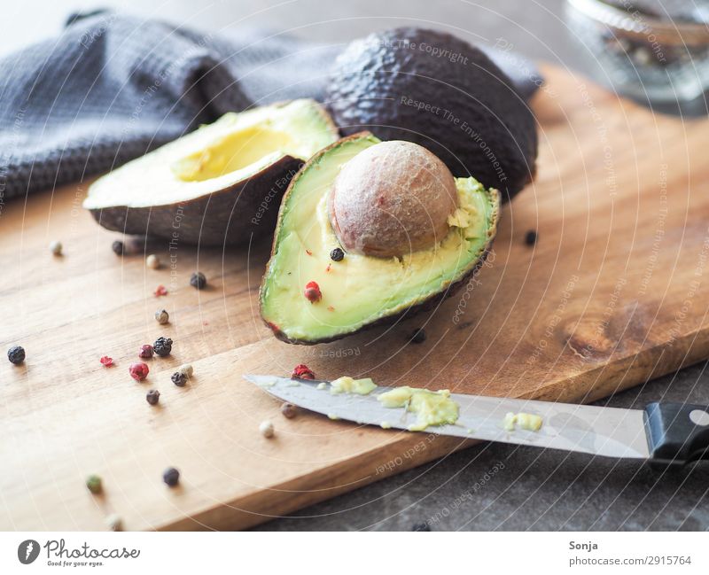 Avocado with core on a wooden board Food Vegetable Nutrition Organic produce Vegetarian diet Diet Knives Healthy Eating Chopping board To enjoy Colour photo