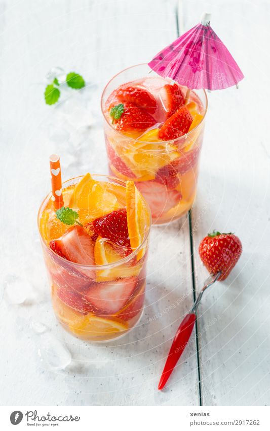 Two glasses with fruity refreshment Fruit Orange Strawberry Lemon Balm Organic produce Vegetarian diet Beverage Cold drink Drinking water Glass Fork