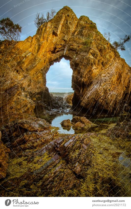 A Natural Arch on the Coast at Golden Hour Vacation & Travel Tourism Beach Ocean Island Environment Nature Landscape Sand Sky Clouds Rock Stone Blue Turquoise