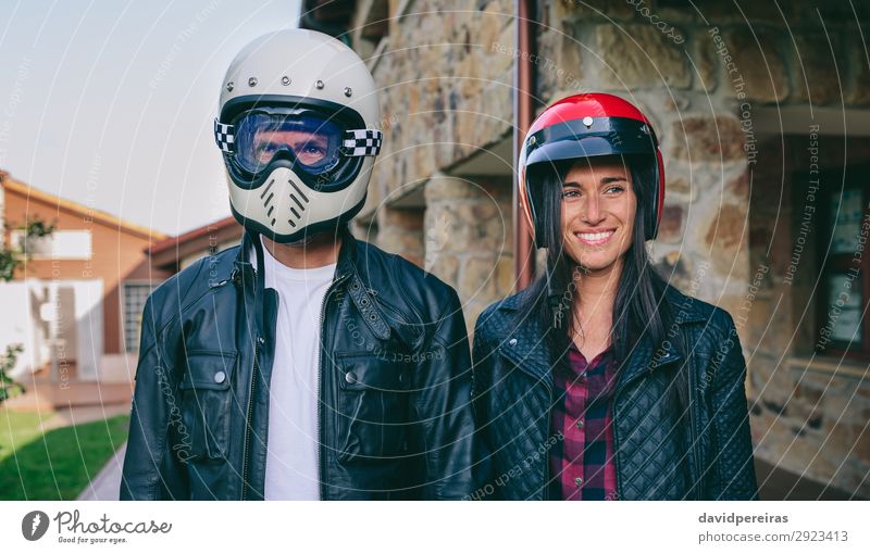 Couple posing with motorcycle helmets Lifestyle Happy Beautiful House (Residential Structure) Human being Woman Adults Man Grass Fashion Smiling Authentic Funny