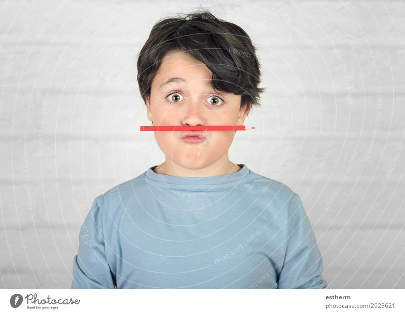 funny child with colored pencil in the mouth against brick background Joy Playing Child School Human being Masculine Infancy 1 8 - 13 years Stationery Think