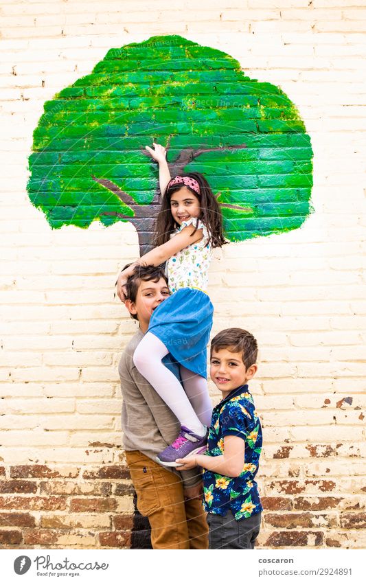 Three kids playing with a tree painted on a wall Lifestyle Joy Happy Leisure and hobbies Playing Children's game Freedom Summer Summer vacation Garden