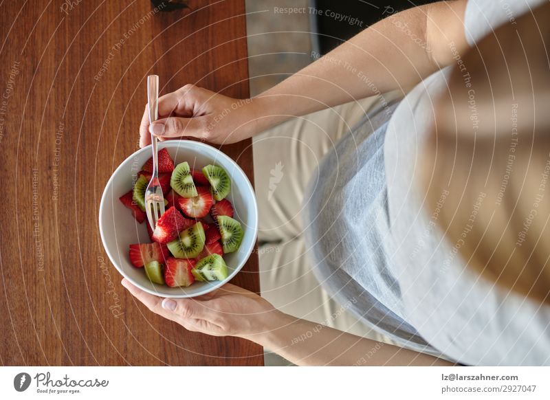 Pregnant woman eating a bowl of fruit salad Fruit Nutrition Eating Diet Bowl Lifestyle Happy Beautiful Woman Adults Mother Body 1 Human being Smiling Sit Above