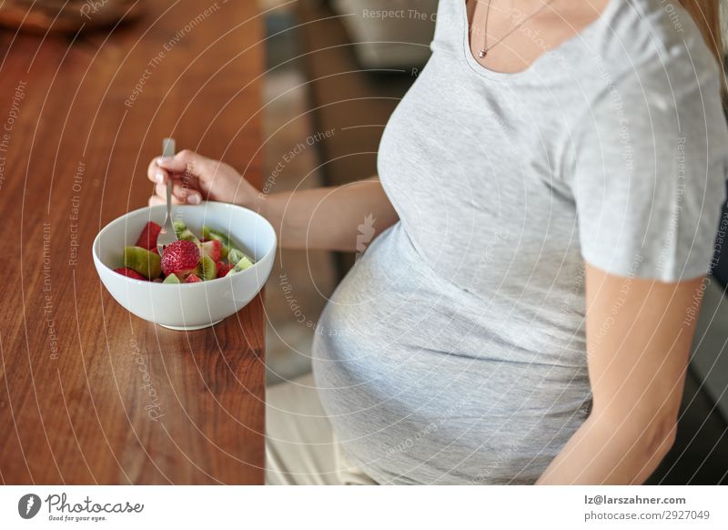 Pregnant woman eating a bowl of fruit salad with fresh strawberries Fruit Nutrition Eating Diet Bowl Lifestyle Happy Beautiful Woman Adults Mother Body 1