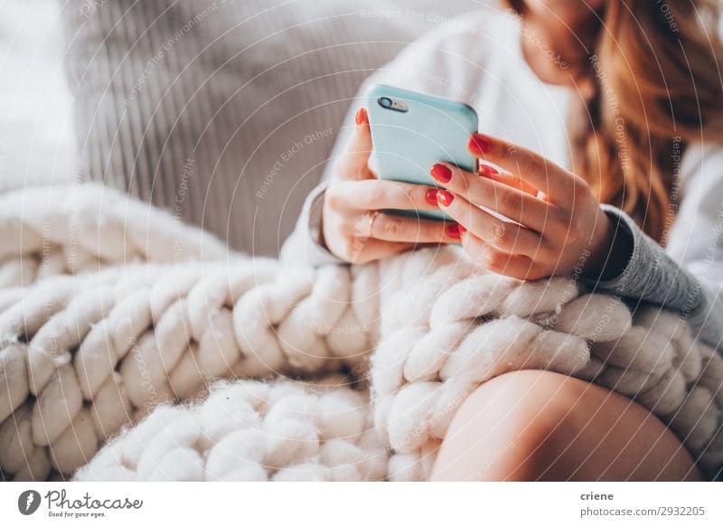 woman sitting on couch with wool blanket and smartphone Lifestyle Design Happy Beautiful Relaxation Leisure and hobbies Winter House (Residential Structure)