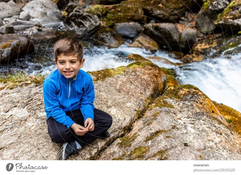 Cute litle boy sitting near of a wild river Lifestyle Style Joy Happy Beautiful Leisure and hobbies Vacation & Travel Expedition Summer Mountain Hiking Child