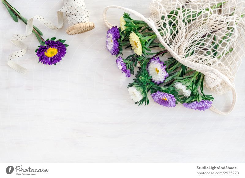 Asters in a mesh bag on white wooden background Food Shopping Design Joy Beautiful Summer Garden Decoration Gardening Nature Plant Flower Blossom Bouquet String