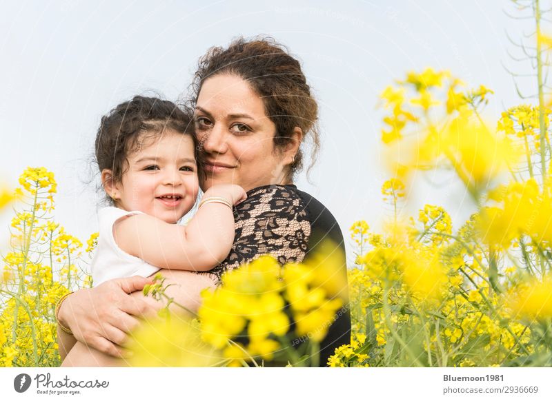 Young happy mother embraced her cute little girl at canola field Lifestyle Joy Beautiful Well-being Adventure Summer Mother's Day Parenting Child Girl