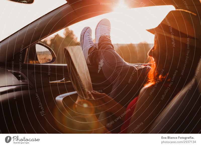 Modern girl resting in a car at sunset Lifestyle Joy Relaxation Reading Vacation & Travel Trip Adventure Summer Sun Feminine Young woman Youth (Young adults)