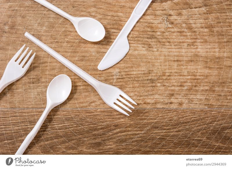 Disposable plastic cutlery on wooden table. Top view Kitchen Plastic Table Crockery Recycling empty Environment Fork garbage Group Industrial Birthday knife