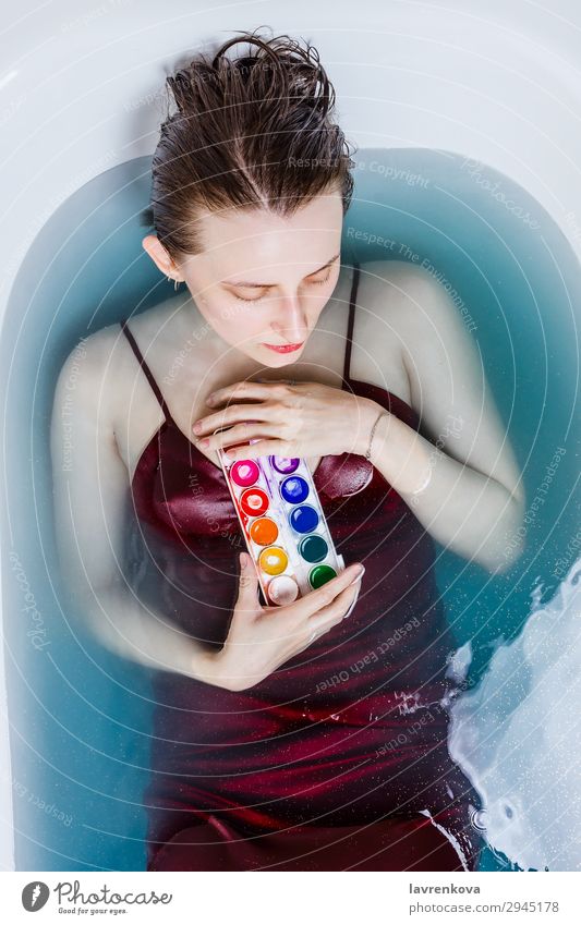 female in bathtub filled with blue water holding water-colors Artist Attractive Bathtub Blue Caucasian Creativity Dress Face Woman Home Lifestyle