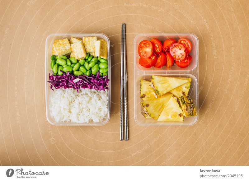 Healthy asian-style vegan bento box flat lay cherry tomatoes Cut Pineapple Red cabbage Tasty Green Cooking metal chopsticks take away lunch box zero waste