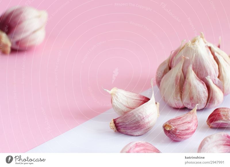 Fresh garlic on a light pink background Vegetable Herbs and spices Vegetarian diet Decline Garlic bulb ingrerient Clove pastel food health healthy Organic Raw