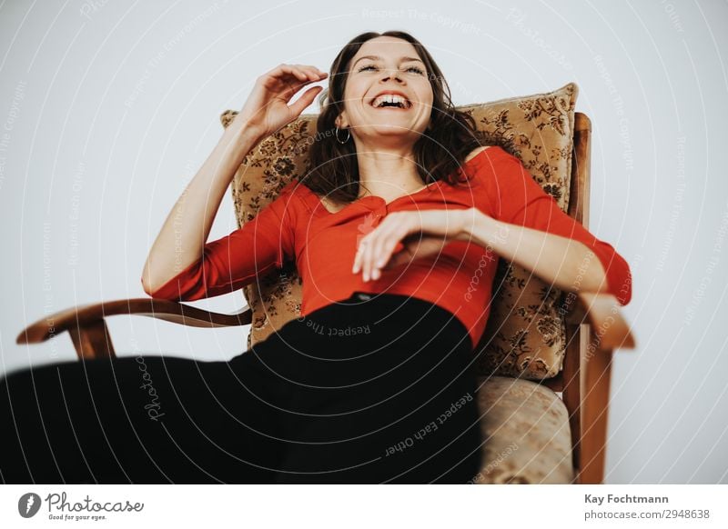 Woman sitting in armchair laughing Lifestyle Contentment Living or residing Flat (apartment) Armchair Feminine Young woman Youth (Young adults) Adults