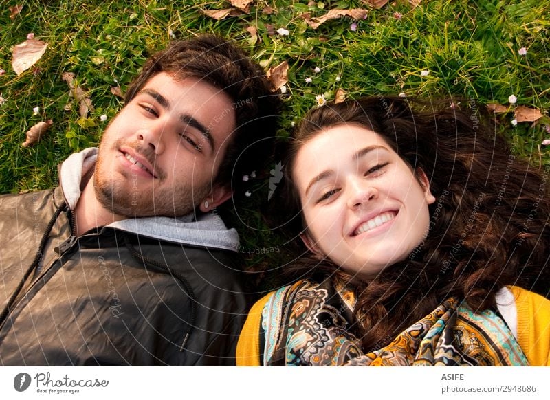 a couple of teenagers lying in the grass Lifestyle Joy Happy Beautiful Relaxation Leisure and hobbies Human being Woman Adults Man Sister Friendship Couple