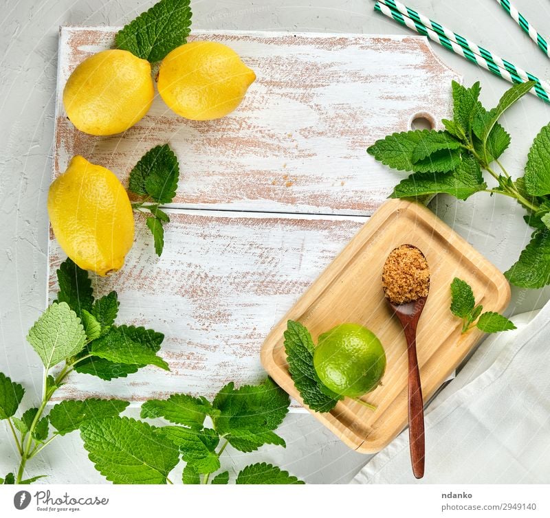 whole lemons and lime, brown sugar Fruit Herbs and spices Lemonade Juice Spoon Table Leaf Tube Wood Fresh Above Juicy Brown Yellow Green White bunch citrus