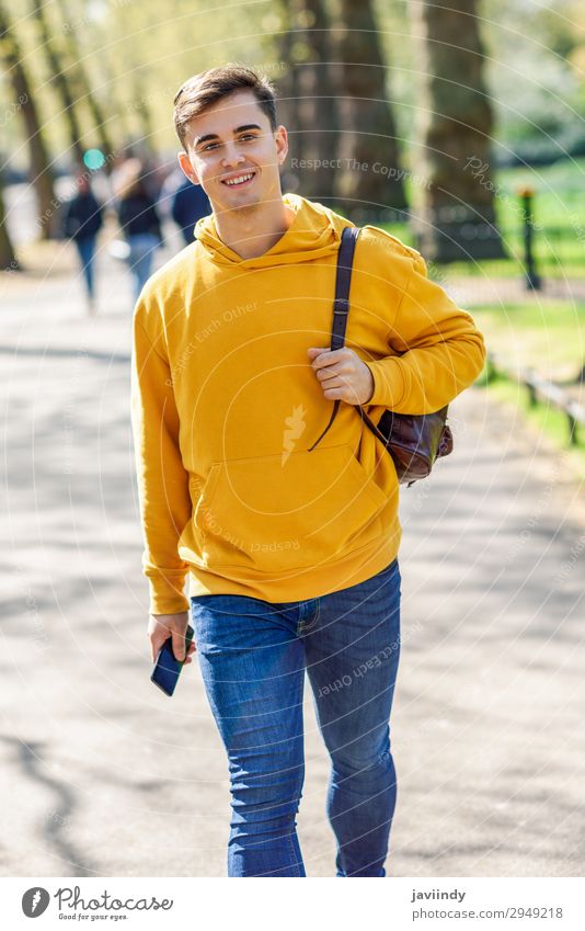 Young urban man using smartphone walking in street in an urban park Lifestyle Happy Vacation & Travel Telephone PDA Technology Human being Masculine Young man