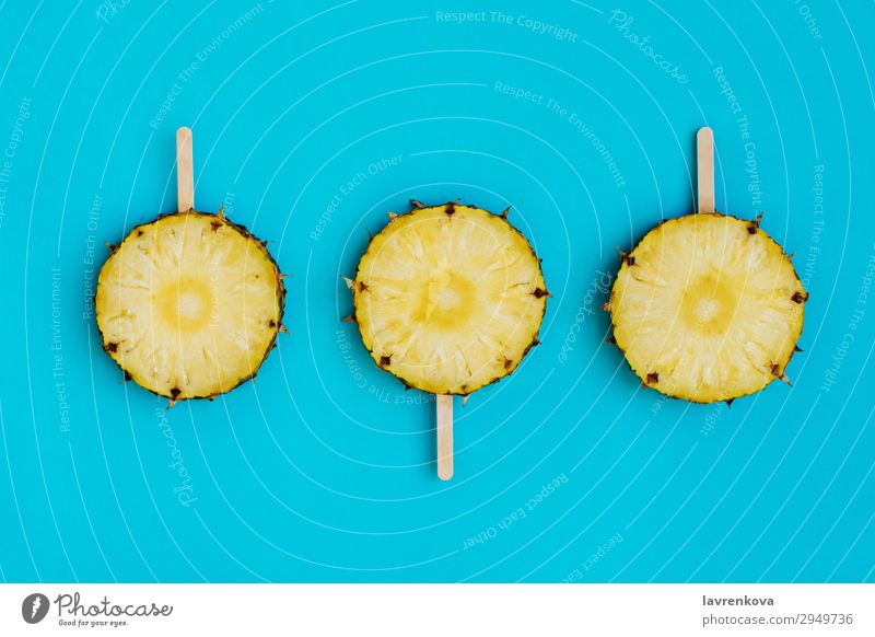 circles of pineapple on a wooden popsicle sticks Dessert Sweet Candy Food Healthy Eating Dish Food photograph Stick Wood Blue Turquoise Cyan Fruit Pineapple