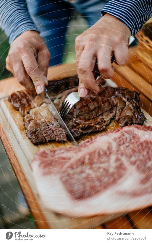 hands of a man cutting slices of grilled kobe beef barbecue bbq beefsteak cuisine culinary delicates entrecote expensive fat filet fillet flavour fork gourmet