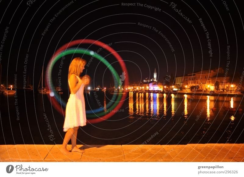 Woman plays light - Poi in the evening in front of a harbour town Young woman Youth (Young adults) Illuminate Playing Sports Vacation & Travel Night life Fire