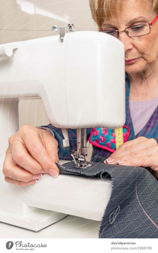 Senior seamstress woman working on sewing machine Design Handcrafts Work and employment Profession Industry Craft (trade) Sewing machine Woman Adults Fashion