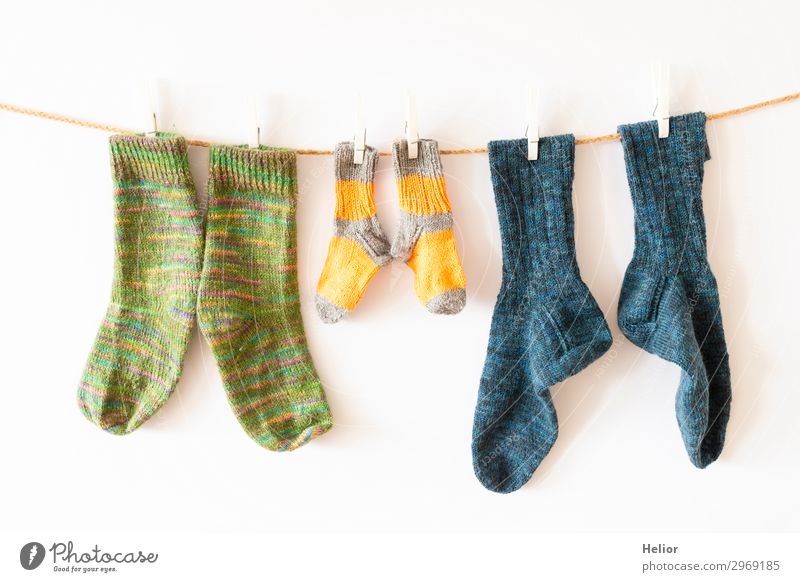 Colourful socks on a clothesline on a white background Style Design Handcrafts Knit Winter Fashion Fresh Retro Warmth Soft Blue Yellow Green White Orderliness