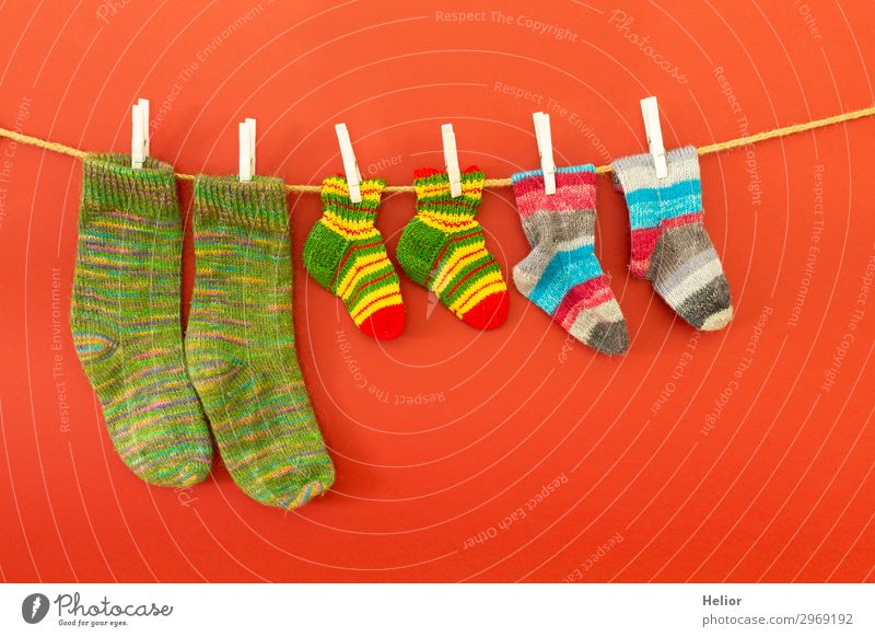 Colourful socks on a clothesline on a red background Style Design Handcrafts Knit Winter Fashion Fresh Retro Dry Warmth Soft Blue Multicoloured Green Red