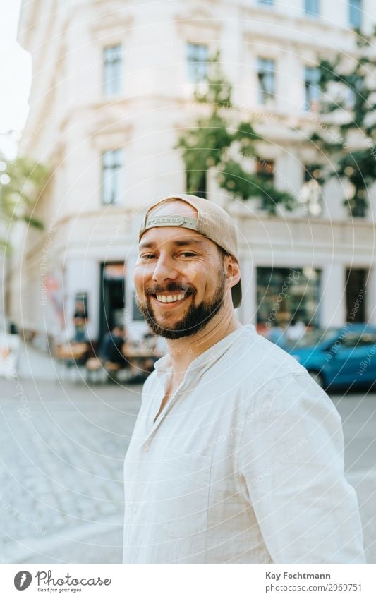bearded smiling man outside attractive baseball cap casual caucasian cheerful citylife confident cool emotion expression face fashion friendly grinning guy