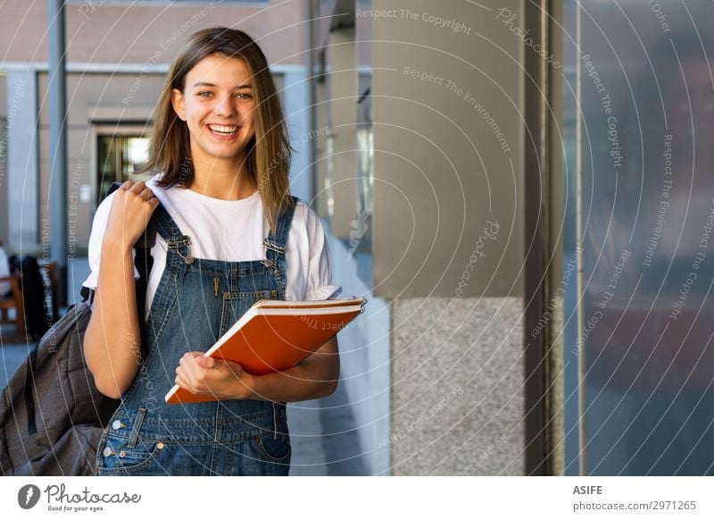 Smiling student girl at the school entrance Lifestyle Happy Beautiful School Academic studies Woman Adults Youth (Young adults) Brunette Laughter Stand Cute