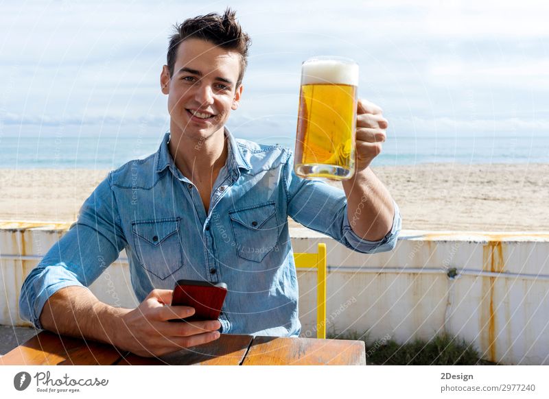 young man sitting on a beach club holding beer Coffee Beer Shopping Summer Beach Table Club Disco Telephone PDA Human being Masculine Man Adults 1 13 - 18 years