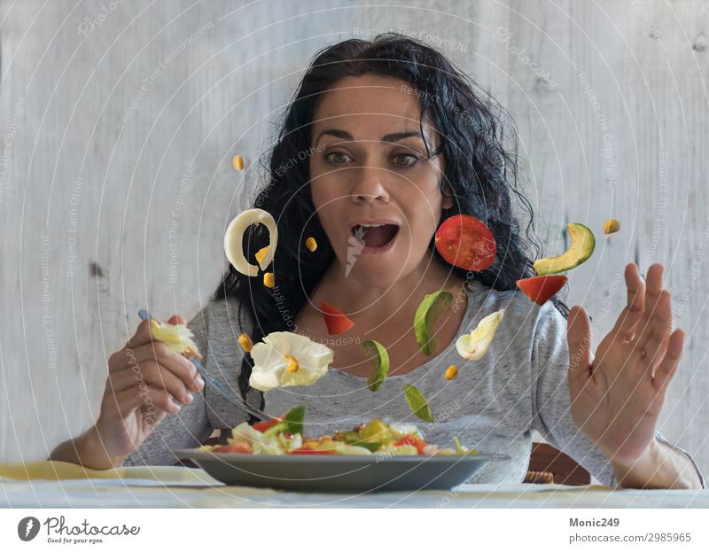 Amazed brunette woman watching flying vegetables in her salad Vegetable Lunch Dinner Diet Plate Fork Lifestyle Happy Healthy Eating Restaurant Woman Adults