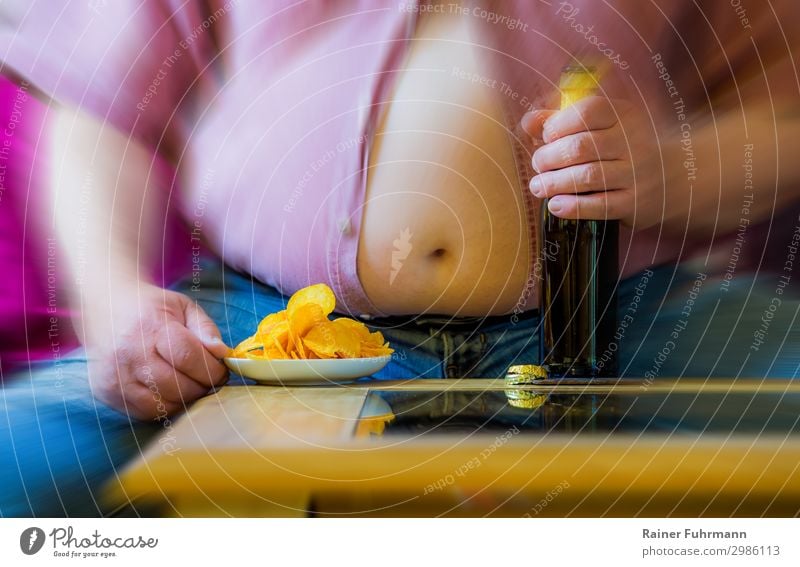 A man with a big belly is sitting at a table. On the table are beer and potato chips. Human being Masculine Man Adults Male senior Stomach 1 Shirt Jeans Eating