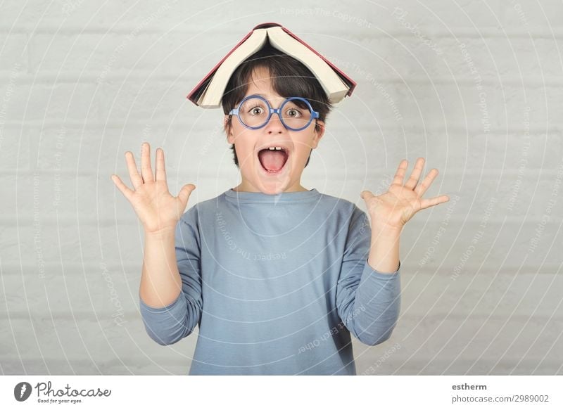 happy and smiling child with book on head Lifestyle Joy Playing Reading Child School Schoolchild Human being Masculine Boy (child) Infancy 1 8 - 13 years Book
