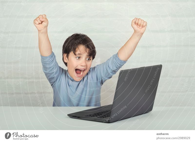 Happy child with laptop computer on brick background Joy Leisure and hobbies Playing Entertainment Success Child School Computer Screen Software Technology