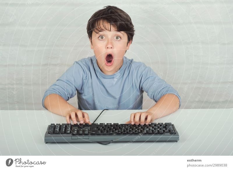 surprised child with keyboard Lifestyle Playing Computer Keyboard Software Technology Entertainment electronics Internet Human being Masculine Child Infancy 1