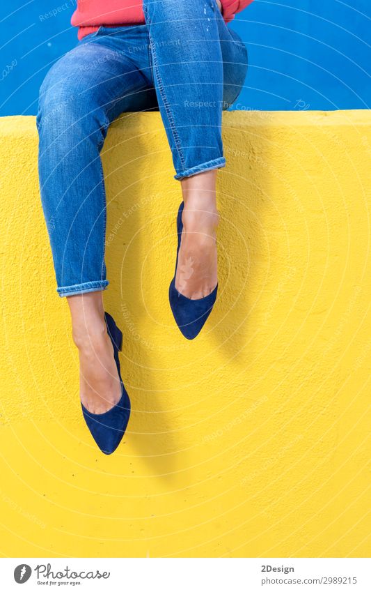 Closeup view of woman heels on a yellow wall Lifestyle Style Beautiful Relaxation Summer Human being Woman Adults Feet Warmth Fashion Jeans Footwear High heels