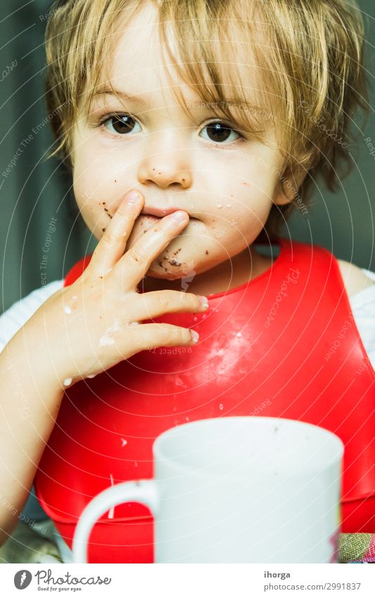 portrait adorable child eating chocolate sponge cake attribute baby background bib boy brown candy childhood cute delicious desert dessert dirty fat flavour
