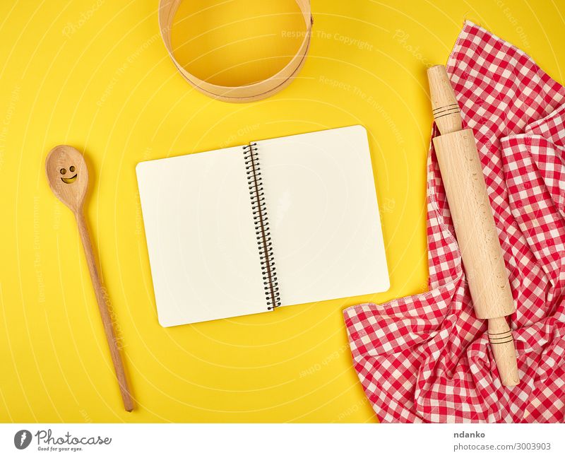 open notebook and wooden kitchen accessories Spoon Kitchen Tool Book Nature Sieve Paper Wood Write Natural Above Yellow Red White background Blank