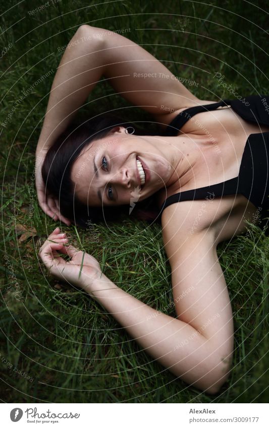 Portrait of a young, smiling woman in the grass Lifestyle Joy luck already Well-being Relaxation Young woman Youth (Young adults) Face 18 - 30 years Adults