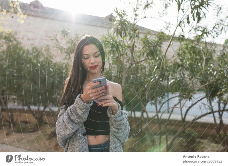 Young woman looking smartphone in afternoon image Lifestyle PDA Internet Human being Woman Adults Brunette Smiling communication City young social networking