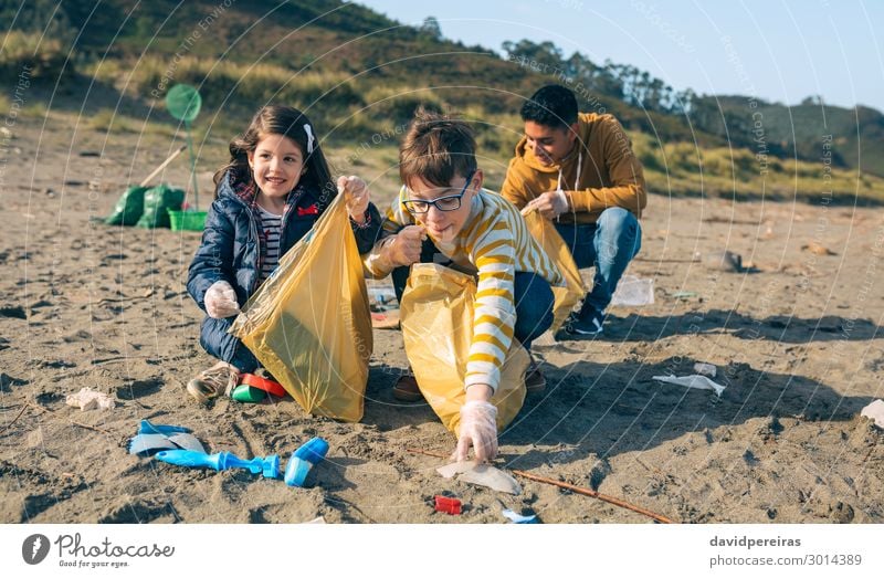 Young volunteers cleaning the beach Happy Camping Beach Child Work and employment Human being Boy (child) Woman Adults Man Group Sand Plastic Smiling Dirty