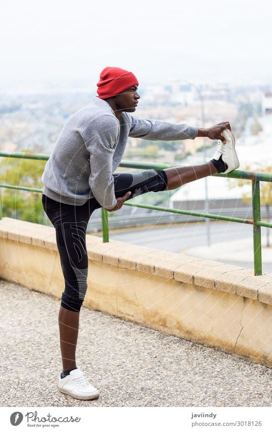 Black man doing stretching before running outdoors. Lifestyle Body Winter Sports Jogging Human being Masculine Young man Youth (Young adults) Man Adults Legs 1