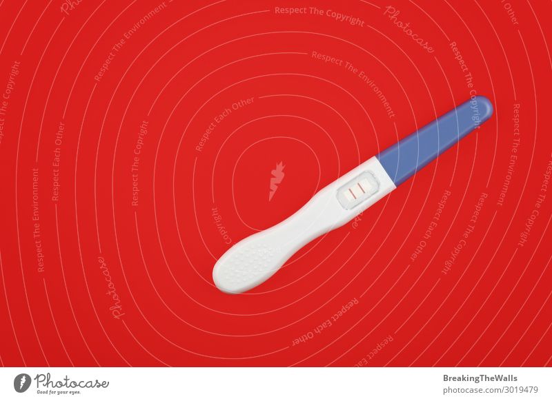 Close up positive pregnancy test over red Healthy Health care Medication Stripe Success Above Pregnant Red Joy Happiness Anticipation Responsibility