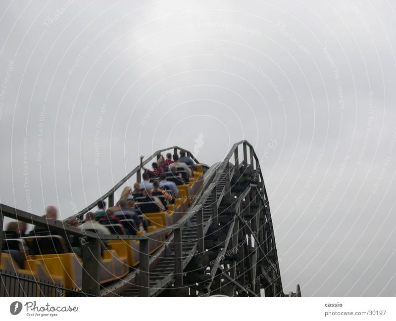Ride up. Roller coaster Amusement Park Soltau Driving heath park Sky Human being Upward Bright background Copy Space top Clouds in the sky Cloud cover Skyward