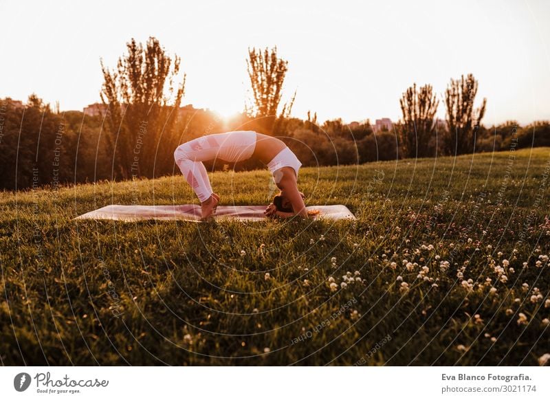 young beautiful asian woman doing yoga in a park at sunset. Lifestyle Happy Beautiful Body Harmonious Relaxation Meditation Leisure and hobbies Summer Music